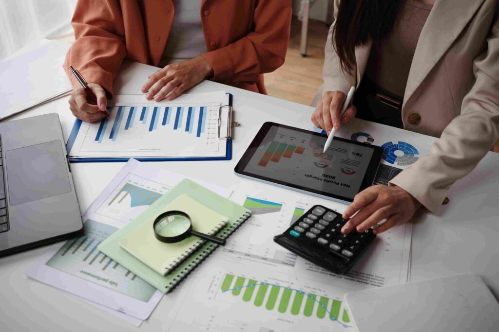 Finance professionals reviewing charts, reports, and a tablet with financial data during an analysis meeting
