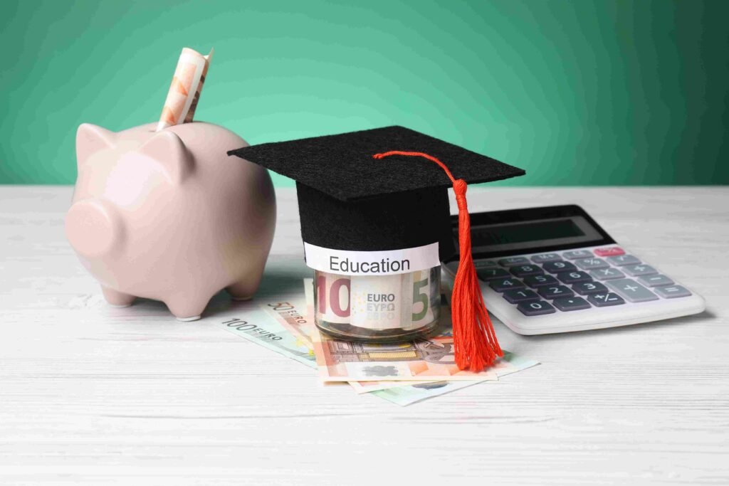 Graduation cap on savings jar with euro banknotes, piggy bank, and calculator representing the cost and value of a finance degree