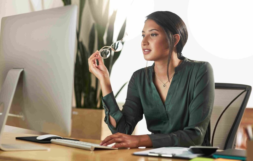 Professional working at a desktop computer in an office, representing career progression into a portfolio management role