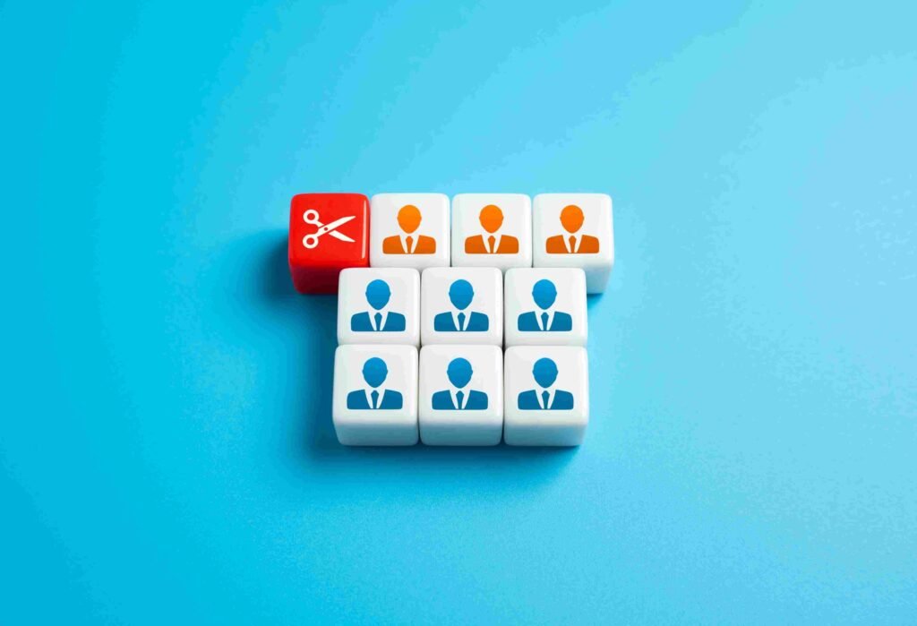 Workforce planning concept showing employee icons and a scissors symbol, representing hiring decisions, restructuring, and staffing plans